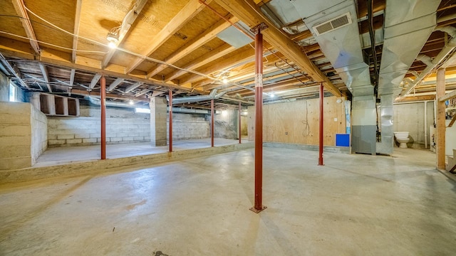 unfinished below grade area featuring visible vents and heating unit