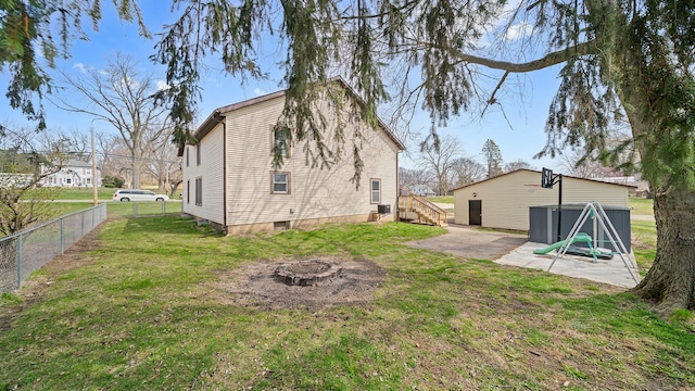 rear view of property featuring a yard, an outdoor fire pit, fence, and a patio
