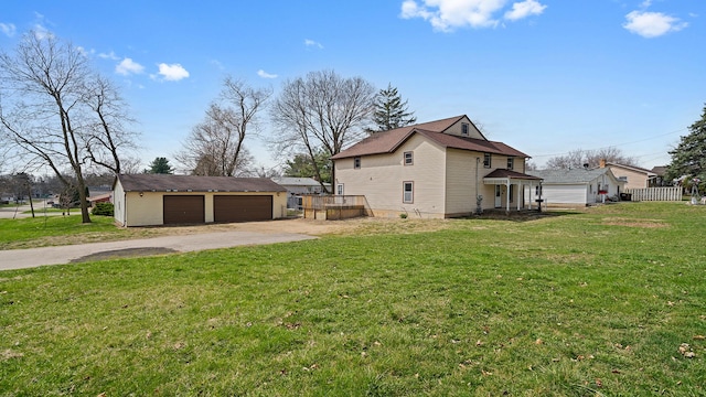 view of home's exterior featuring a yard, driveway, an outbuilding, and a detached garage