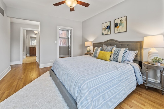 bedroom featuring visible vents, baseboards, ceiling fan, and wood finished floors