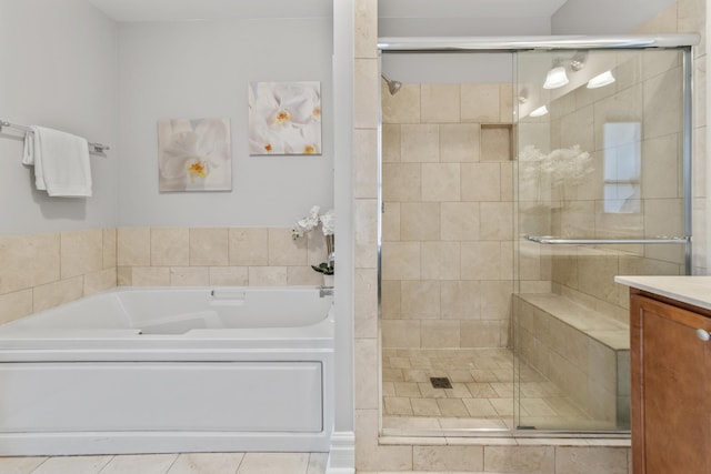 full bathroom featuring tile patterned floors, vanity, a garden tub, and a stall shower
