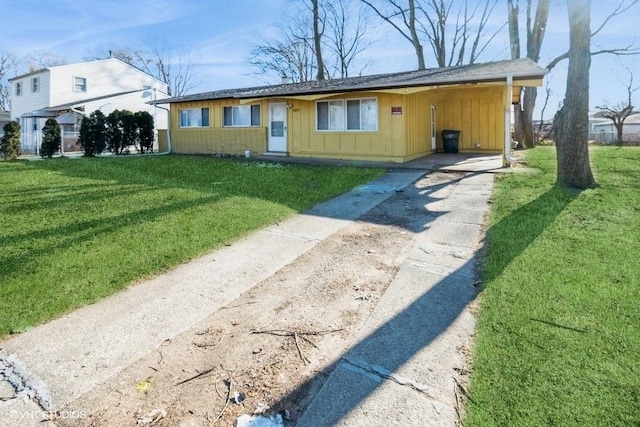 view of front of property with board and batten siding, driveway, and a front lawn