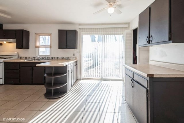 kitchen with light tile patterned flooring, under cabinet range hood, white range with electric stovetop, and a ceiling fan