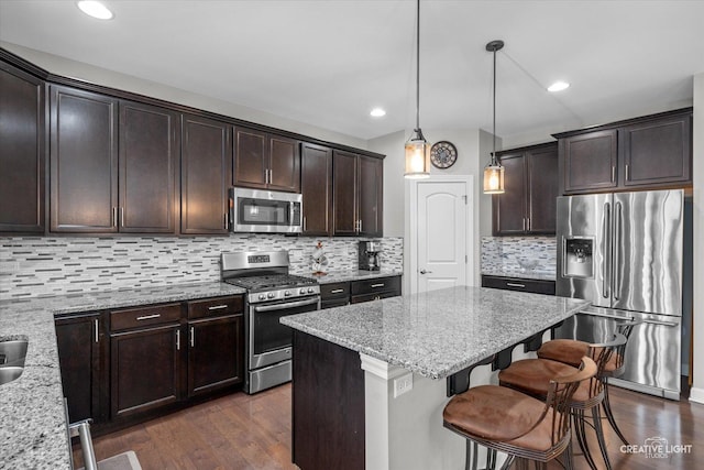 6625 Savanna Ln, Lakewood, IL 60014 - kitchen featuring dark wood finished floors, light stone countertops, appliances with stainless steel finishes, a kitchen island, and dark brown cabinets