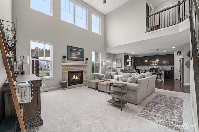 6625 Savanna Ln, Lakewood, IL 60014 - living room featuring light colored carpet, baseboards, a fireplace, a high ceiling, and stairs
