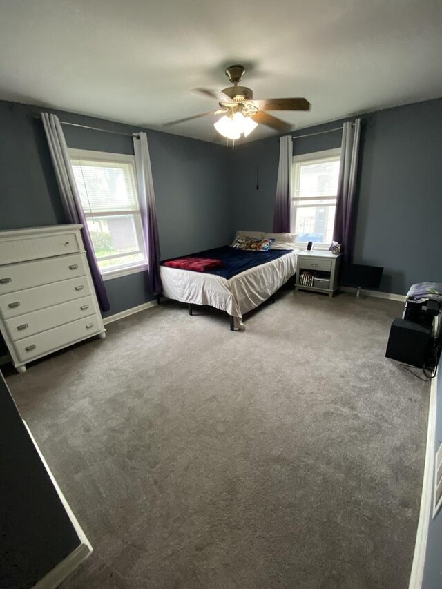 carpeted bedroom with baseboards and a ceiling fan