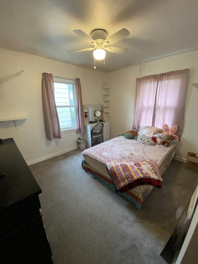 carpeted bedroom featuring baseboards and ceiling fan
