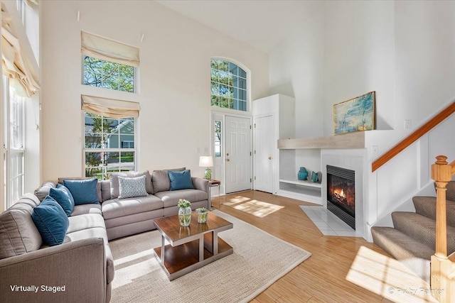 9531 Lenox Ln, Lakewood, IL 60014 - living area with a towering ceiling, a tiled fireplace, stairway, wood finished floors, and built in shelves