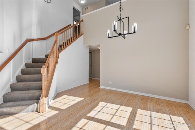 9531 Lenox Ln, Lakewood, IL 60014 - stairway featuring wood finished floors, a chandelier, baseboards, and a towering ceiling