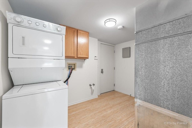 9531 Lenox Ln, Lakewood, IL 60014 - laundry room with stacked washer / dryer, light wood-style flooring, cabinet space, and baseboards