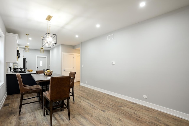 9046 S Racine Ave, Chicago, IL 60620 - dining space featuring baseboards, an inviting chandelier, recessed lighting, light wood-style flooring, and visible vents