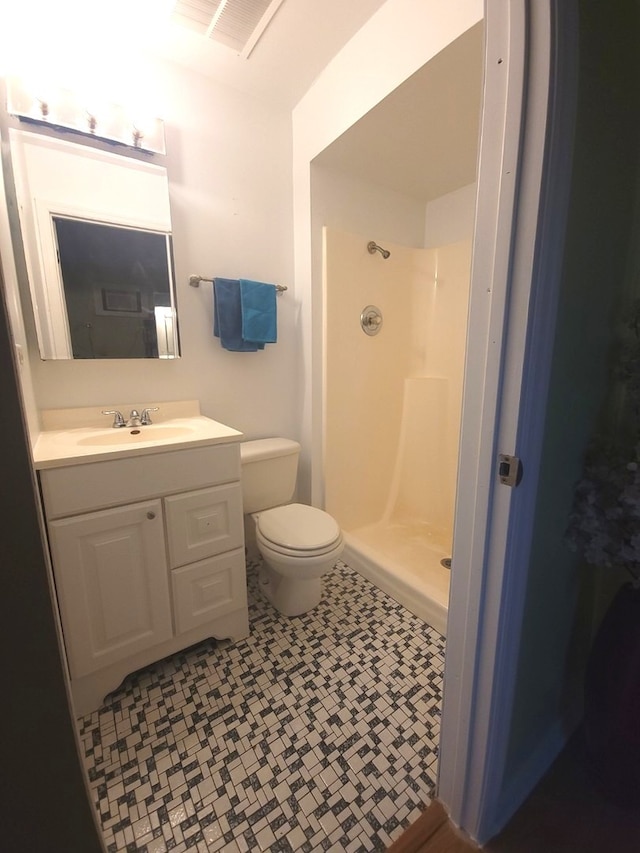 full bathroom with tile patterned floors, vanity, walk in shower, toilet, and visible vents