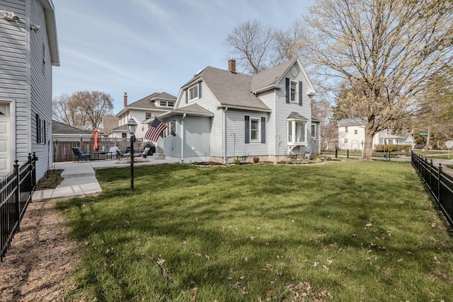 exterior space featuring a fenced backyard, a yard, a residential view, and a patio
