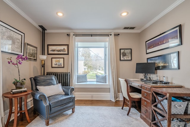 office featuring wood finished floors, radiator, baseboards, ornamental molding, and visible vents