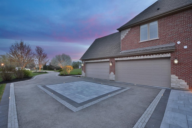 22328 N Prairie Ct, Kildeer, IL 60047 - property exterior at dusk featuring brick siding, a shingled roof, and asphalt driveway