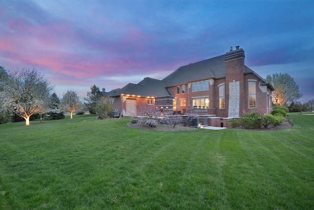 22328 N Prairie Ct, Kildeer, IL 60047 - back of property at dusk featuring a lawn, a chimney, and brick siding