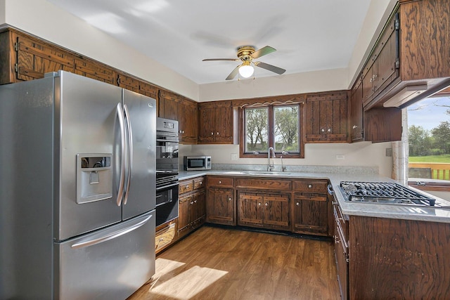 kitchen featuring a healthy amount of sunlight, ceiling fan, a sink, dark wood finished floors, and appliances with stainless steel finishes
