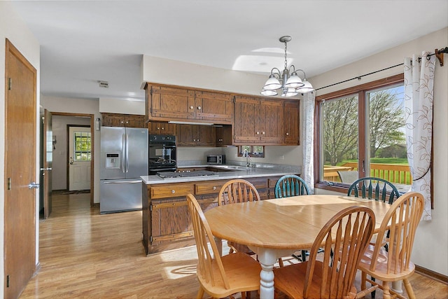 dining area with a notable chandelier, a wealth of natural light, visible vents, and light wood-type flooring