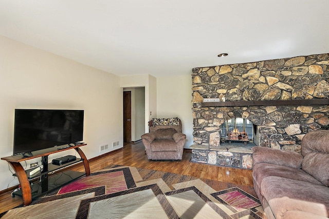 living area with baseboards, wood finished floors, and a fireplace