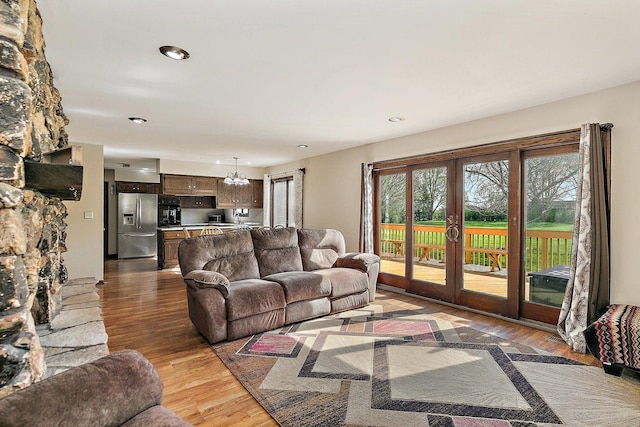 living area with french doors, recessed lighting, wood finished floors, and an inviting chandelier