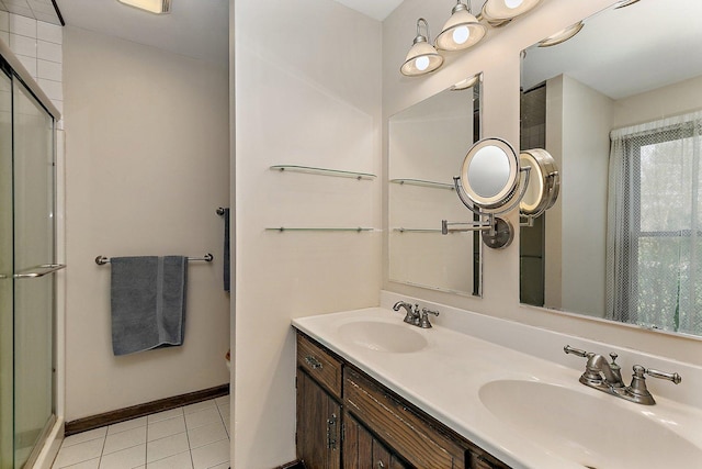 bathroom with a shower with door, tile patterned floors, and a sink