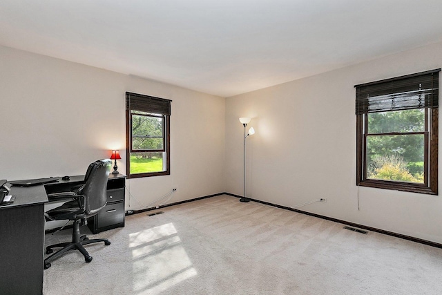 office area featuring visible vents, baseboards, and light colored carpet