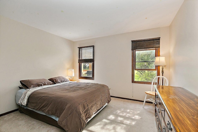 bedroom with baseboards and light carpet
