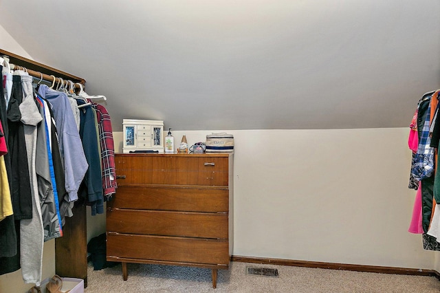 walk in closet featuring carpet flooring, lofted ceiling, and visible vents