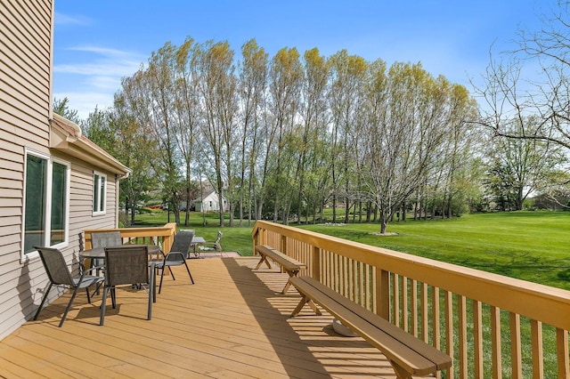 wooden deck with a lawn and outdoor dining space