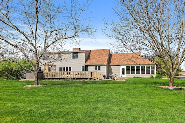 back of house with a chimney, a lawn, and a deck