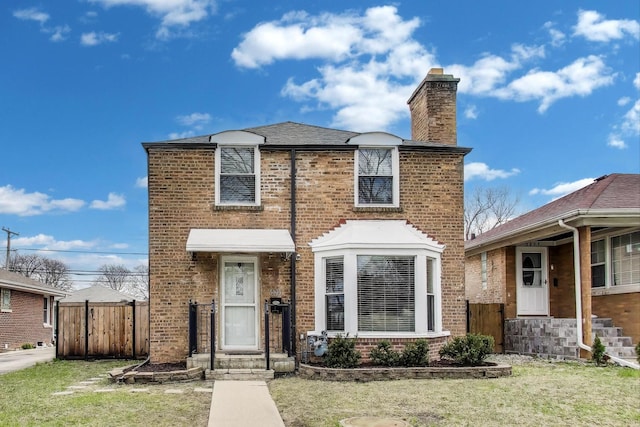 view of front of property featuring brick siding, fence, and a front yard