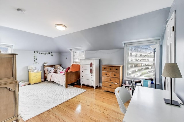 bedroom featuring light wood-style flooring and vaulted ceiling
