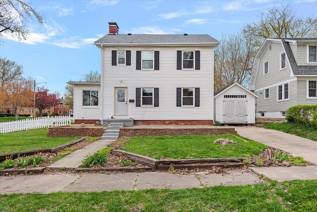 1980 W Forest Ave, Decatur, IL 62522 - colonial inspired home with a front yard, a chimney, fence, a storage unit, and an outbuilding