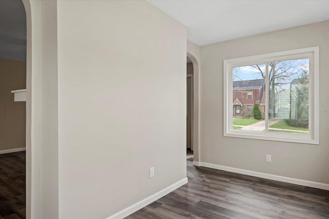 1980 W Forest Ave, Decatur, IL 62522 - unfurnished room with arched walkways, baseboards, and dark wood finished floors
