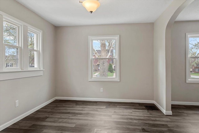1980 W Forest Ave, Decatur, IL 62522 - spare room with arched walkways, visible vents, baseboards, and dark wood finished floors