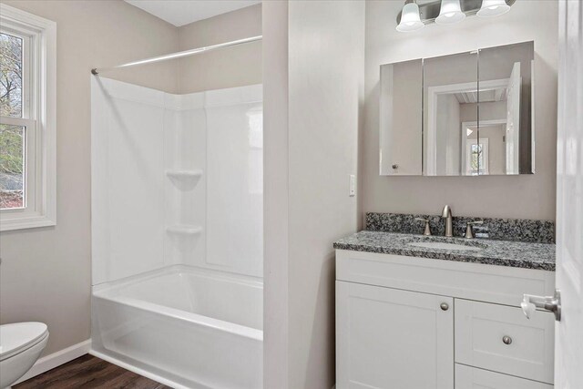 1980 W Forest Ave, Decatur, IL 62522 - bathroom with baseboards, toilet, shower / bath combination, wood finished floors, and vanity