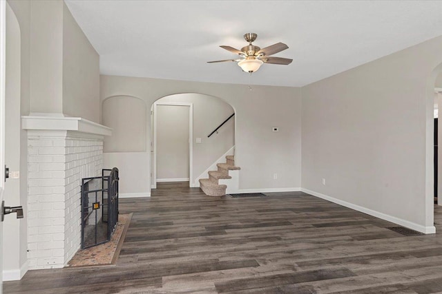1980 W Forest Ave, Decatur, IL 62522 - unfurnished living room featuring ceiling fan, arched walkways, wood finished floors, stairs, and baseboards