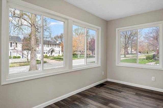 1980 W Forest Ave, Decatur, IL 62522 - unfurnished room with a wealth of natural light, baseboards, and dark wood-style floors