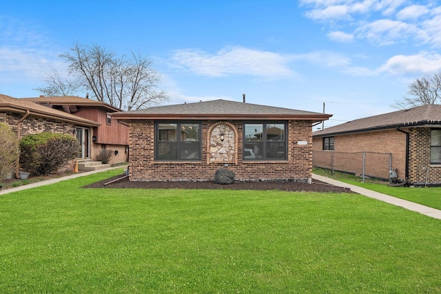 back of property featuring a lawn, brick siding, and fence