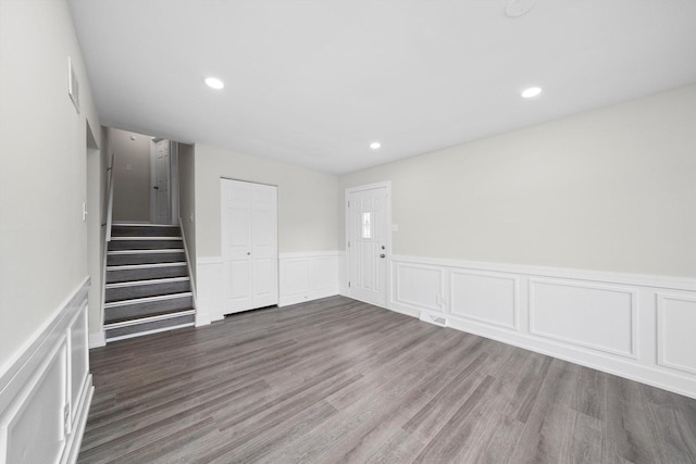 spare room with wainscoting, a decorative wall, stairway, and recessed lighting