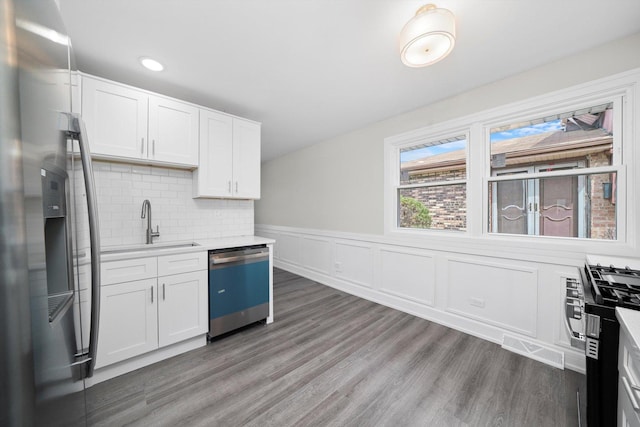 kitchen with a sink, light wood-type flooring, light countertops, appliances with stainless steel finishes, and visible vents