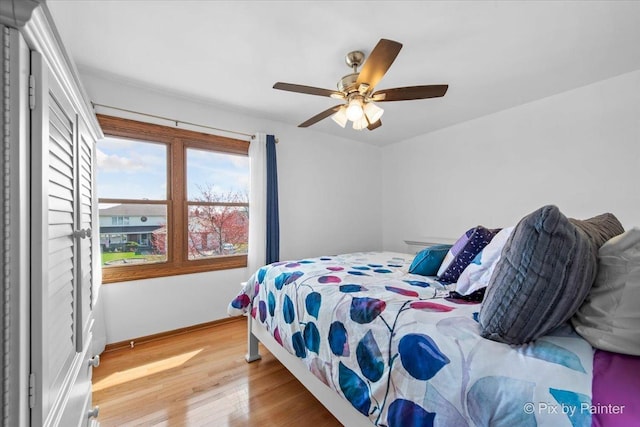 bedroom featuring baseboards, a ceiling fan, and wood finished floors