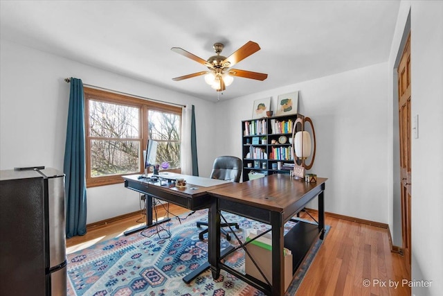 home office with ceiling fan, light wood-type flooring, and baseboards