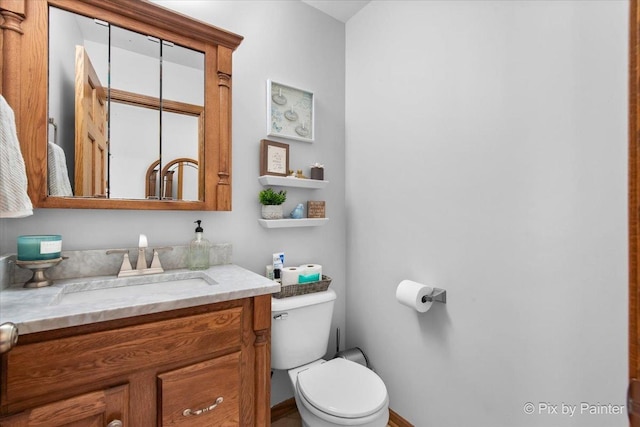 half bathroom featuring toilet and vanity