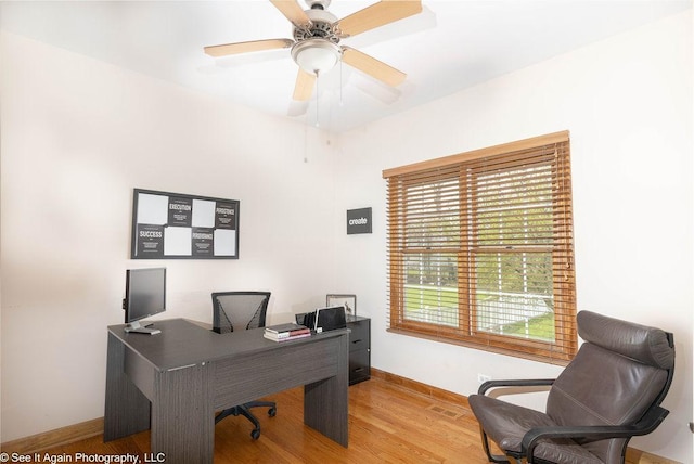 office area with baseboards, ceiling fan, and wood finished floors