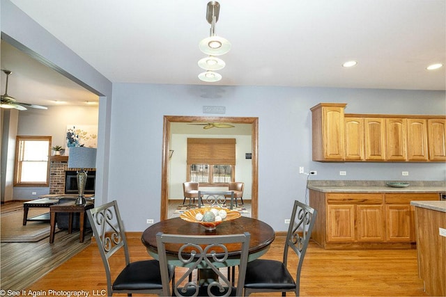dining room with baseboards, a ceiling fan, light wood finished floors, and recessed lighting
