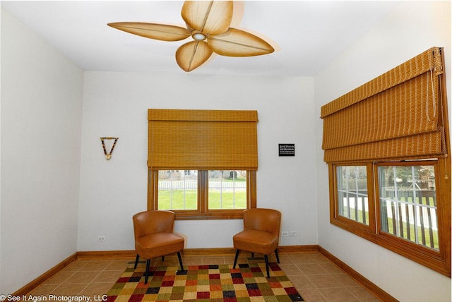 sitting room featuring baseboards, a ceiling fan, and tile patterned floors