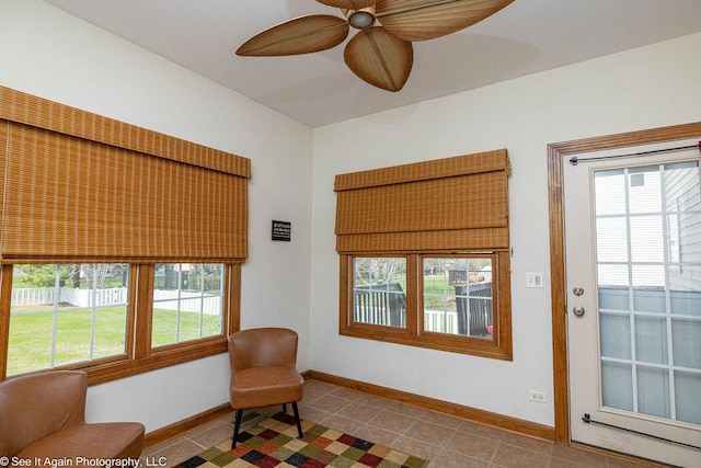 living area with plenty of natural light, a ceiling fan, baseboards, and tile patterned flooring