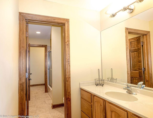 bathroom with toilet, tile patterned flooring, a shower with shower door, and vanity