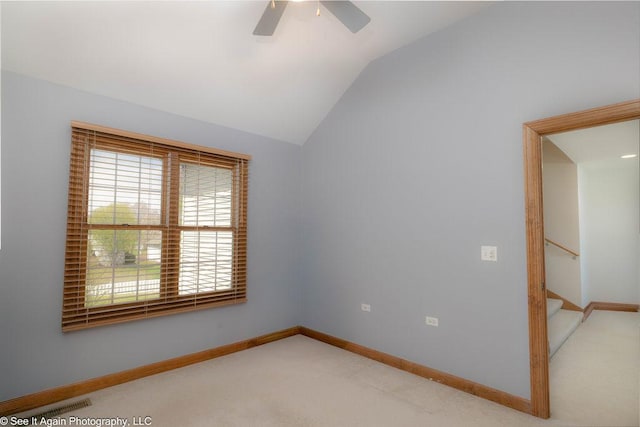 unfurnished room featuring ceiling fan, light colored carpet, visible vents, baseboards, and lofted ceiling